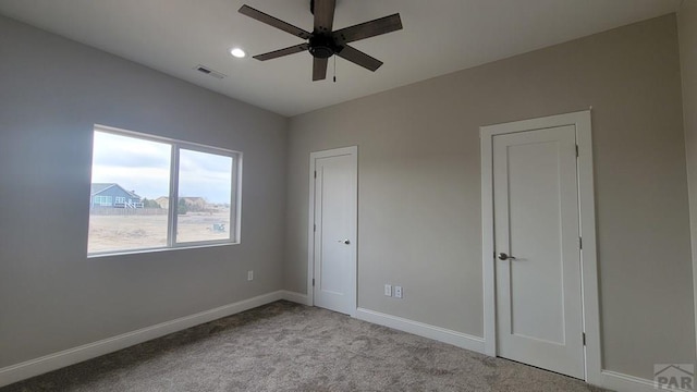 unfurnished bedroom with visible vents, baseboards, carpet, and ceiling fan