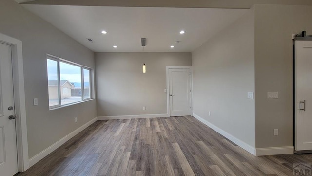 empty room featuring recessed lighting, visible vents, baseboards, and wood finished floors