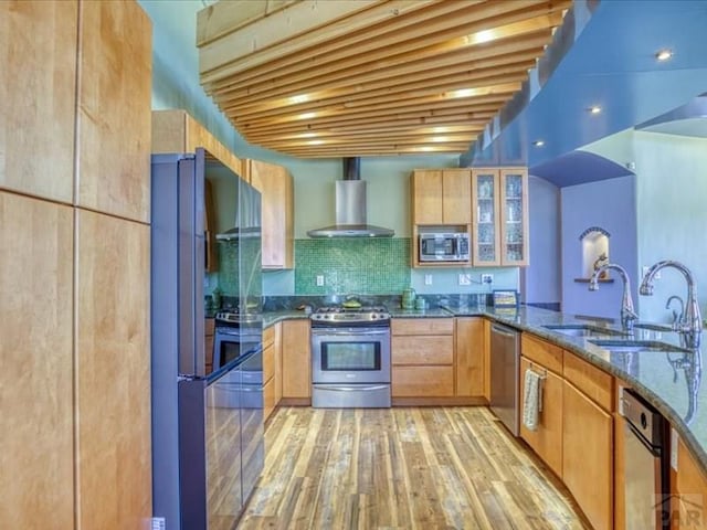 1441 Forest Rd Unit 507 1A, Creede, CO 81130 - kitchen with stainless steel appliances, wall chimney exhaust hood, a sink, dark stone countertops, and light wood-style floors