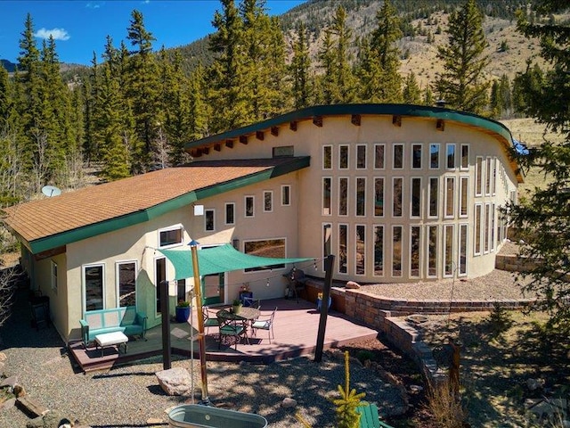 1441 Forest Rd Unit 507 1A, Creede, CO 81130 - back of house with a view of trees, stucco siding, a mountain view, and a patio