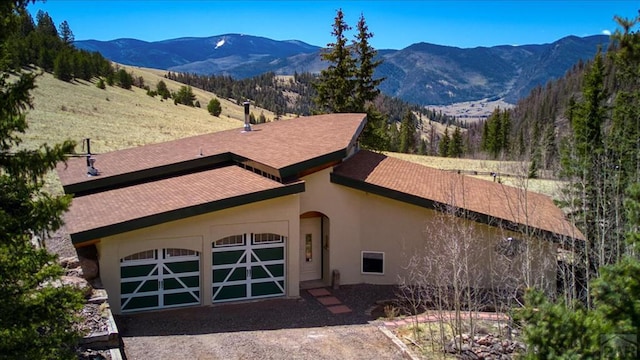 1441 Forest Rd Unit 507 1A, Creede, CO 81130 - view of front of house with a mountain view, stucco siding, and an attached garage