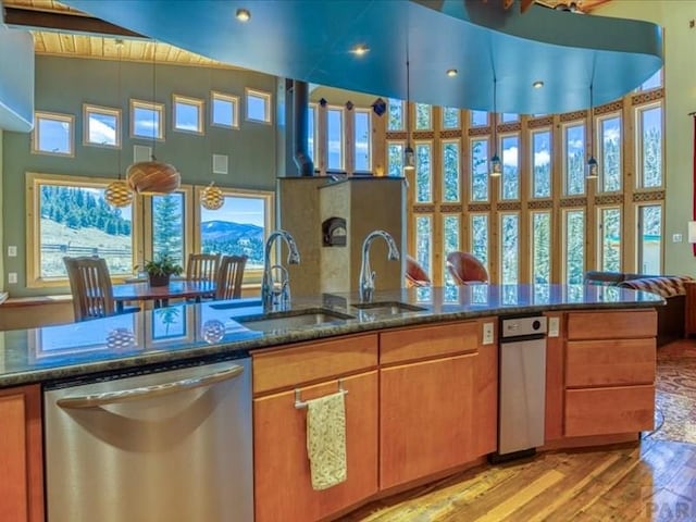 1441 Forest Rd Unit 507 1A, Creede, CO 81130 - kitchen with stainless steel dishwasher, light wood-type flooring, dark stone countertops, and brown cabinets