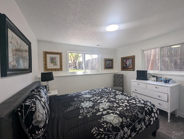 bedroom featuring visible vents, a textured ceiling, and carpet