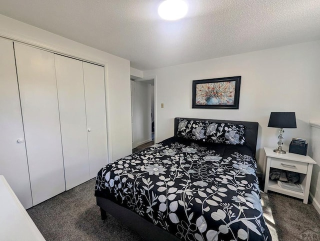 bedroom with a textured ceiling, carpet, and a closet