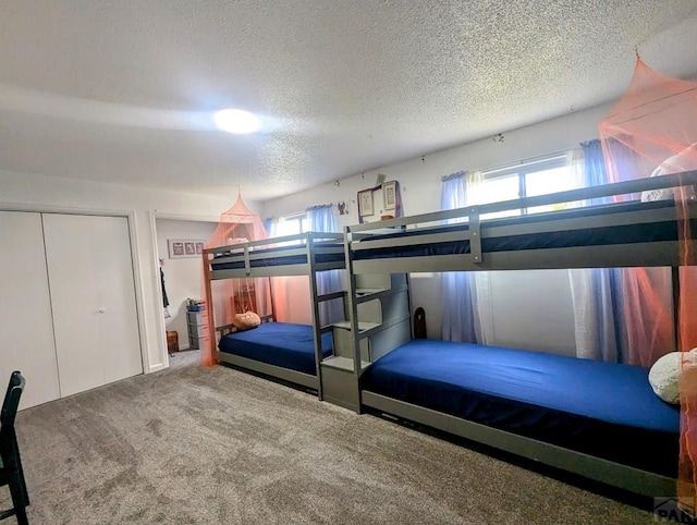 bedroom featuring a textured ceiling, carpet, and multiple windows