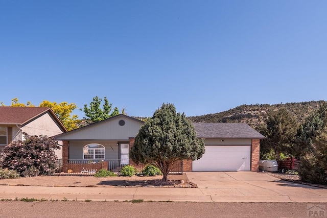 1501 Stonewall, Trinidad, CO 81082 - view of front of home featuring brick siding, concrete driveway, an attached garage, and a porch