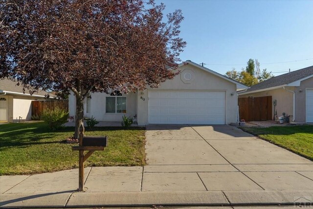 view of front facade featuring stucco siding, concrete driveway, an attached garage, fence, and a front lawn