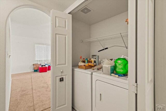 washroom with light carpet, laundry area, visible vents, and washer and clothes dryer