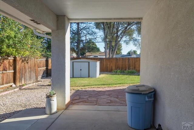 view of patio with a storage shed, a fenced backyard, and an outdoor structure