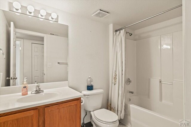 bathroom with toilet, visible vents, shower / bath combination with curtain, and vanity