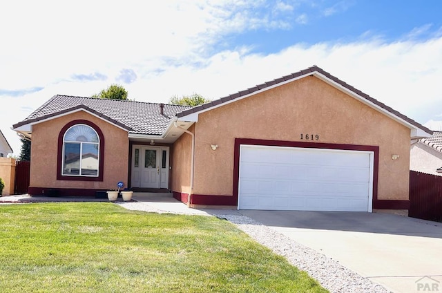 ranch-style home with a garage, a front yard, stucco siding, driveway, and a tile roof