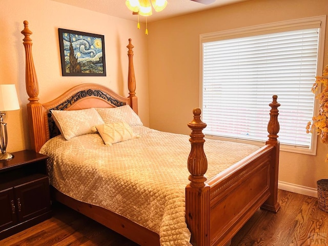 bedroom with dark wood-style flooring, baseboards, and multiple windows