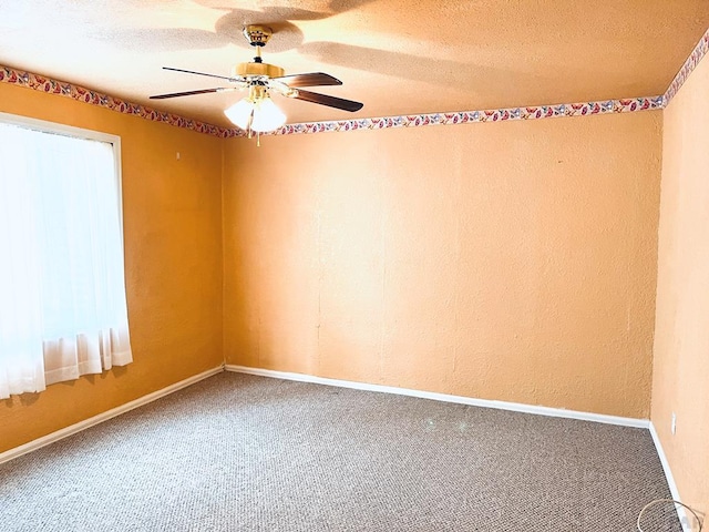 spare room featuring a textured ceiling, ceiling fan, baseboards, and carpet