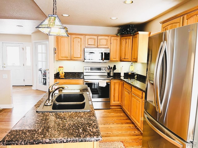 kitchen featuring a sink, stainless steel appliances, recessed lighting, and light wood-style flooring