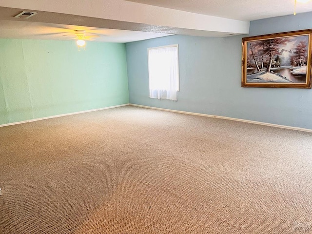 spare room featuring visible vents, carpet, ceiling fan, and baseboards