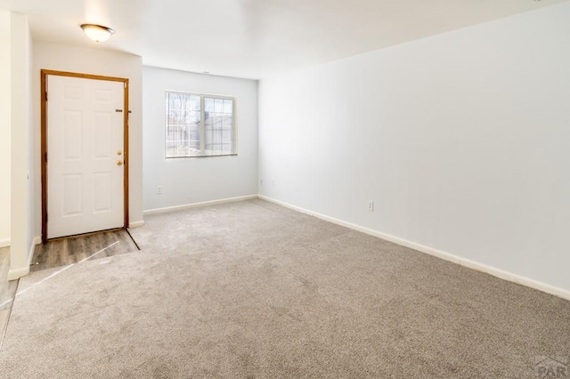 carpeted spare room with baseboards