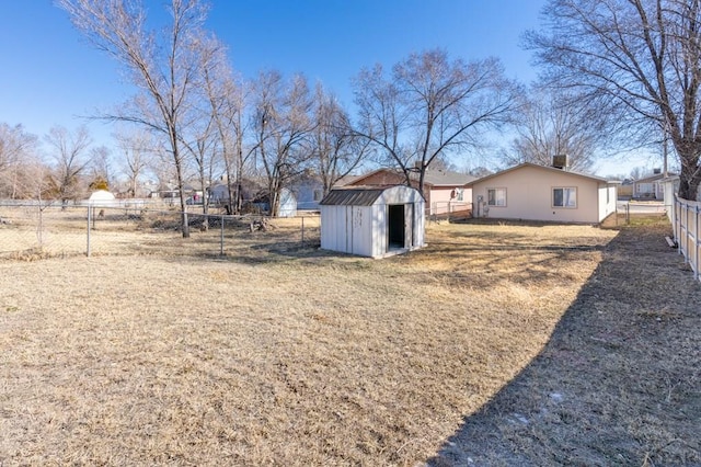 view of yard featuring a shed, an outdoor structure, and fence