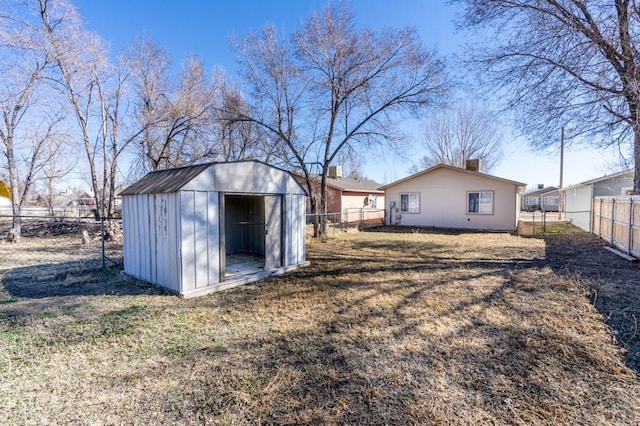 view of yard with a storage shed, an outdoor structure, and a fenced backyard