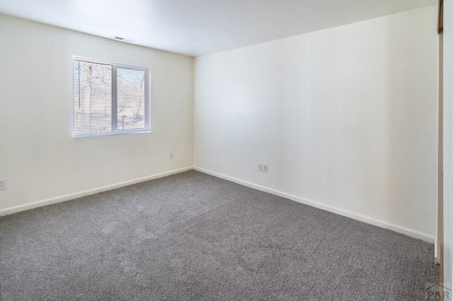 carpeted spare room with visible vents and baseboards