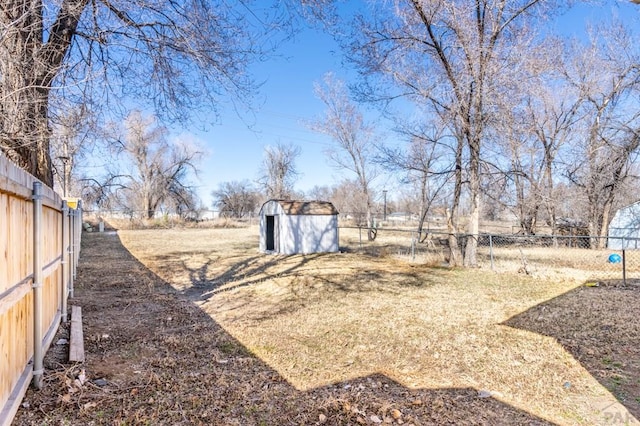 view of yard with an outbuilding, a fenced backyard, and a shed