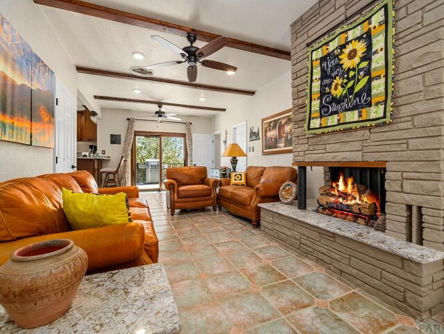 living area with a stone fireplace, recessed lighting, a ceiling fan, visible vents, and beamed ceiling
