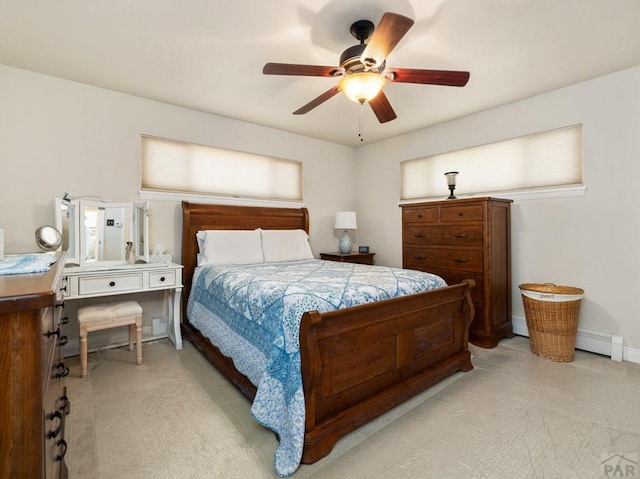 bedroom featuring ceiling fan, light colored carpet, a baseboard heating unit, and baseboards
