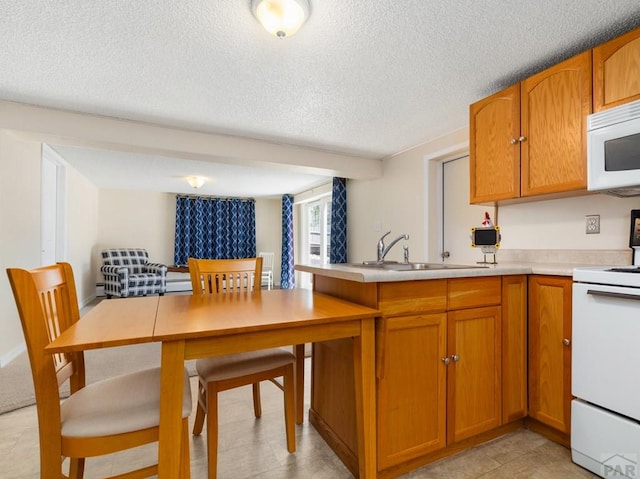 kitchen featuring brown cabinets, white microwave, electric range, and a textured ceiling