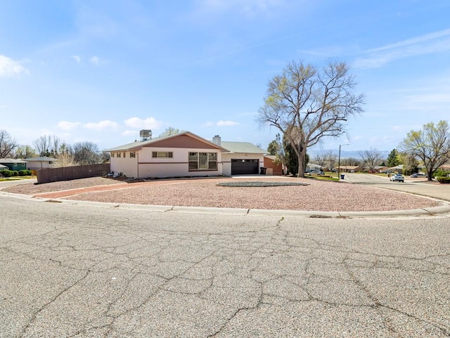 ranch-style home with concrete driveway and fence
