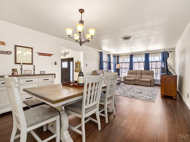 dining room featuring a chandelier, dark wood finished floors, and visible vents