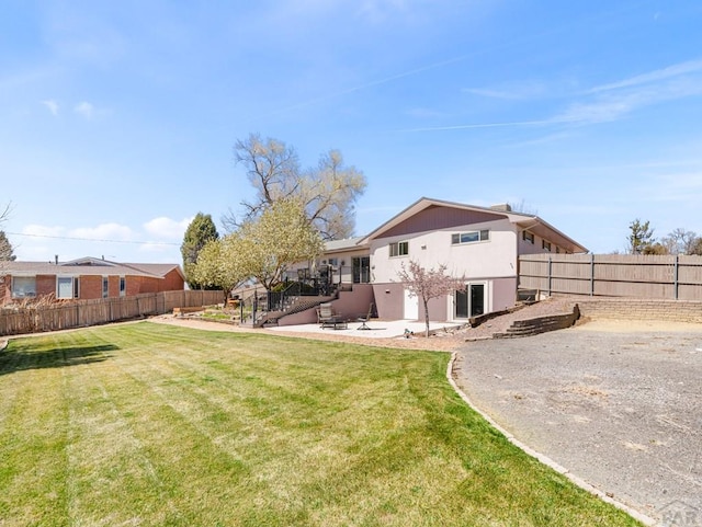 back of property with a patio, a fenced backyard, stucco siding, and a lawn