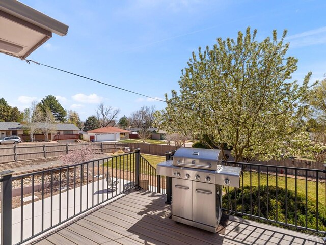 deck featuring a yard, a residential view, a fenced backyard, and a grill