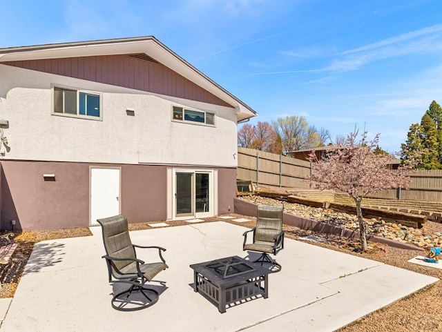 rear view of property with a patio area, fence, a fire pit, and stucco siding