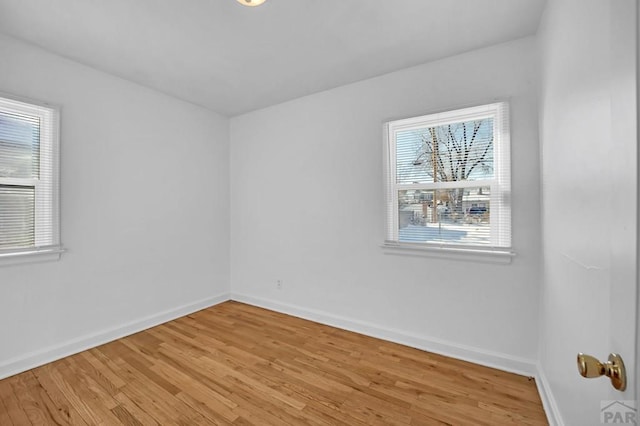 unfurnished room featuring baseboards and light wood-style floors