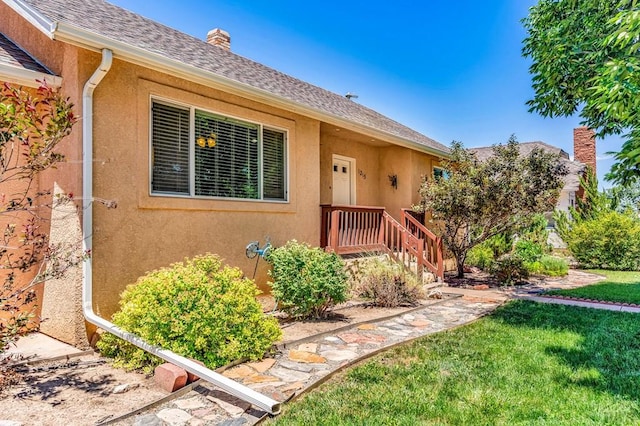 1215 Greenwood Ave, Canon City, CO 81212 - property entrance with stucco siding, a yard, a chimney, and a shingled roof