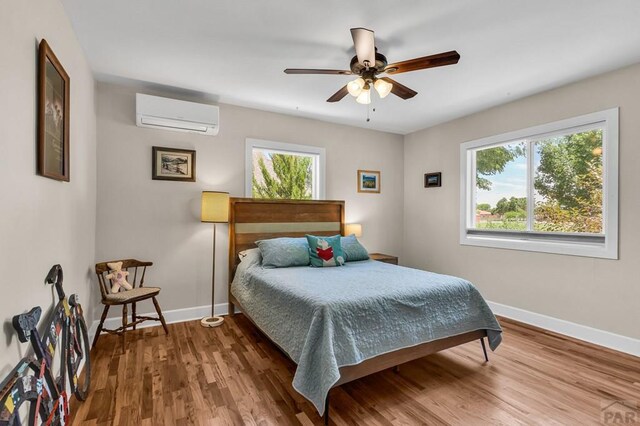 1215 Greenwood Ave, Canon City, CO 81212 - bedroom featuring an AC wall unit, wood finished floors, and ceiling fan