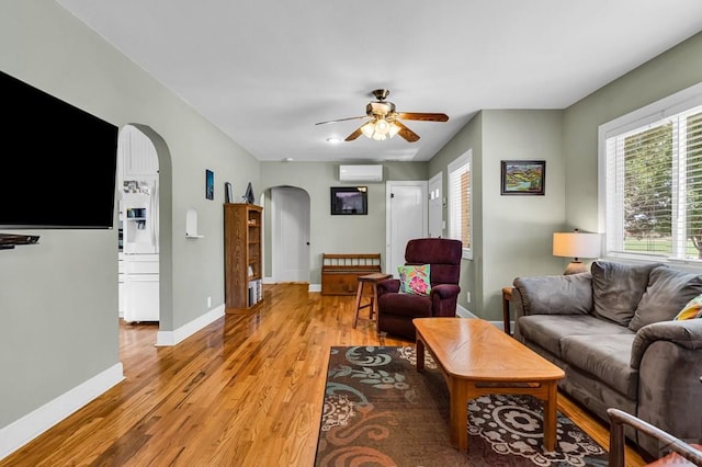 1215 Greenwood Ave, Canon City, CO 81212 - living room featuring arched walkways, ceiling fan, light wood-style flooring, and an AC wall unit