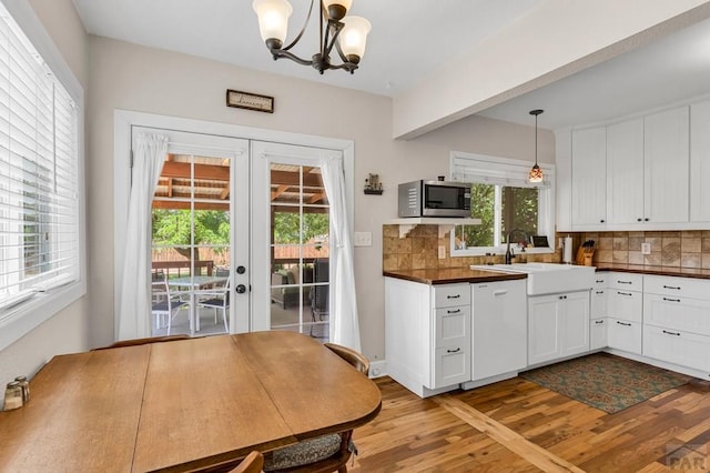 1215 Greenwood Ave, Canon City, CO 81212 - kitchen with white dishwasher, stainless steel microwave, light wood finished floors, dark countertops, and french doors
