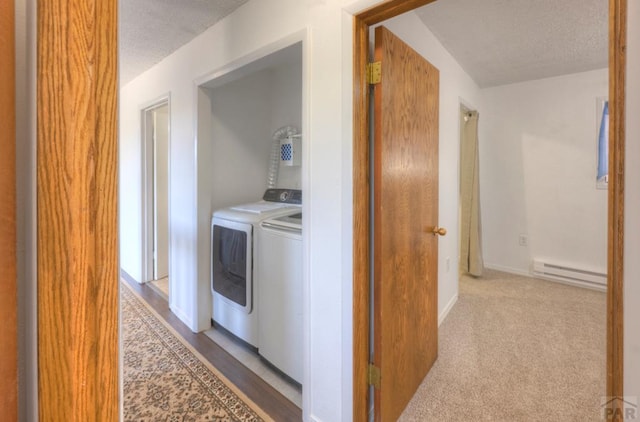 2000 Comanche Dr, Walsenburg, CO 81089 - washroom featuring a baseboard radiator, a textured ceiling, and independent washer and dryer