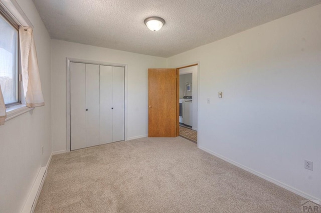 2000 Comanche Dr, Walsenburg, CO 81089 - unfurnished bedroom featuring carpet flooring, a closet, a textured ceiling, washer / dryer, and baseboards