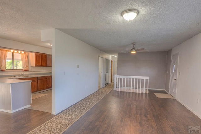 2000 Comanche Dr, Walsenburg, CO 81089 - unfurnished room featuring a textured ceiling, wood finished floors, ceiling fan, a sink, and baseboards