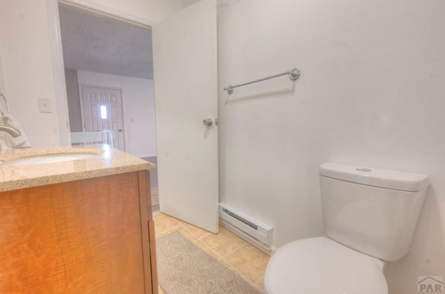 2000 Comanche Dr, Walsenburg, CO 81089 - half bathroom featuring a baseboard heating unit, vanity, toilet, and tile patterned floors