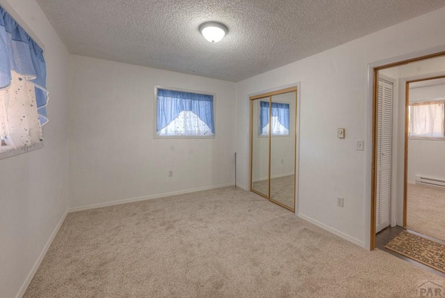 2000 Comanche Dr, Walsenburg, CO 81089 - unfurnished bedroom with carpet flooring, a baseboard heating unit, a textured ceiling, and a closet