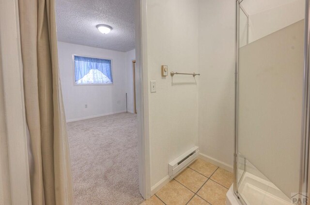 2000 Comanche Dr, Walsenburg, CO 81089 - full bathroom with a textured ceiling, a baseboard radiator, a shower stall, baseboards, and tile patterned flooring