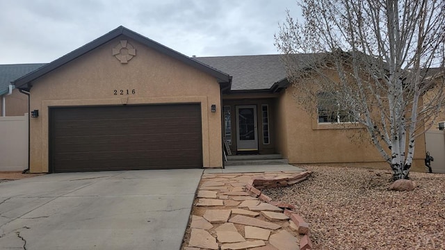 ranch-style home with stucco siding, concrete driveway, and an attached garage