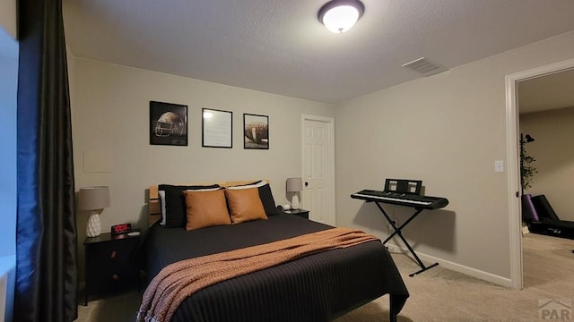 bedroom featuring a textured ceiling, baseboards, visible vents, and light carpet