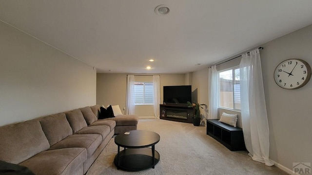 living room featuring recessed lighting, baseboards, and light colored carpet