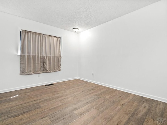 213 Starlite Dr, Pueblo, CO 81005 - empty room featuring a textured ceiling and wood finished floors