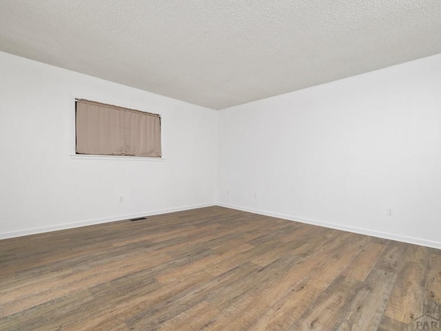 213 Starlite Dr, Pueblo, CO 81005 - spare room featuring dark wood finished floors and a textured ceiling