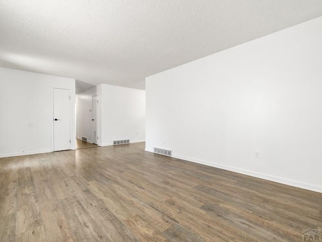 213 Starlite Dr, Pueblo, CO 81005 - unfurnished living room featuring wood finished floors and a textured ceiling