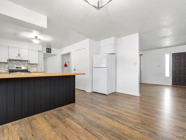 213 Starlite Dr, Pueblo, CO 81005 - kitchen featuring wooden counters, freestanding refrigerator, dark wood-style flooring, a textured ceiling, and white cabinets